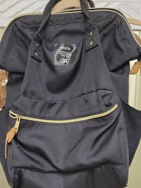 black anello backpack featuring gold-colored zippers.